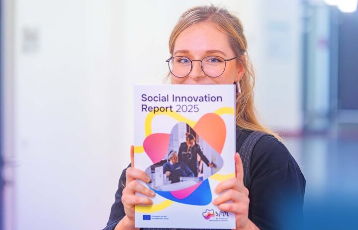 Eine Frau ein Heft hoch und zeigt es in die Kamera. Auf dem Heft steht Social Innovation Report 2025. - Link: Social Innovation Report 2025 - Werft einen Blick rein