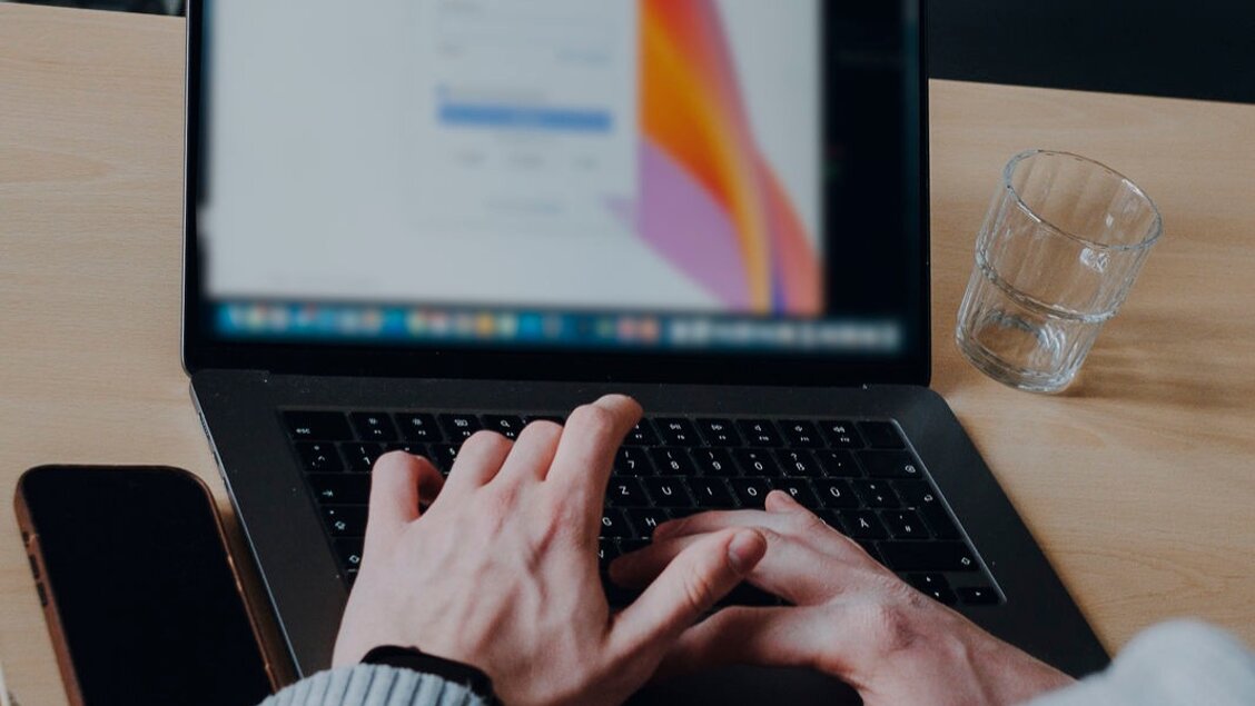 Eine Hand tippt auf einem Laptop. Man sieht nur einen Ausschnitt keinen ganzen Menschen. - SINN Online-Werkstatt für eure Herausforderungen am 23. Juni