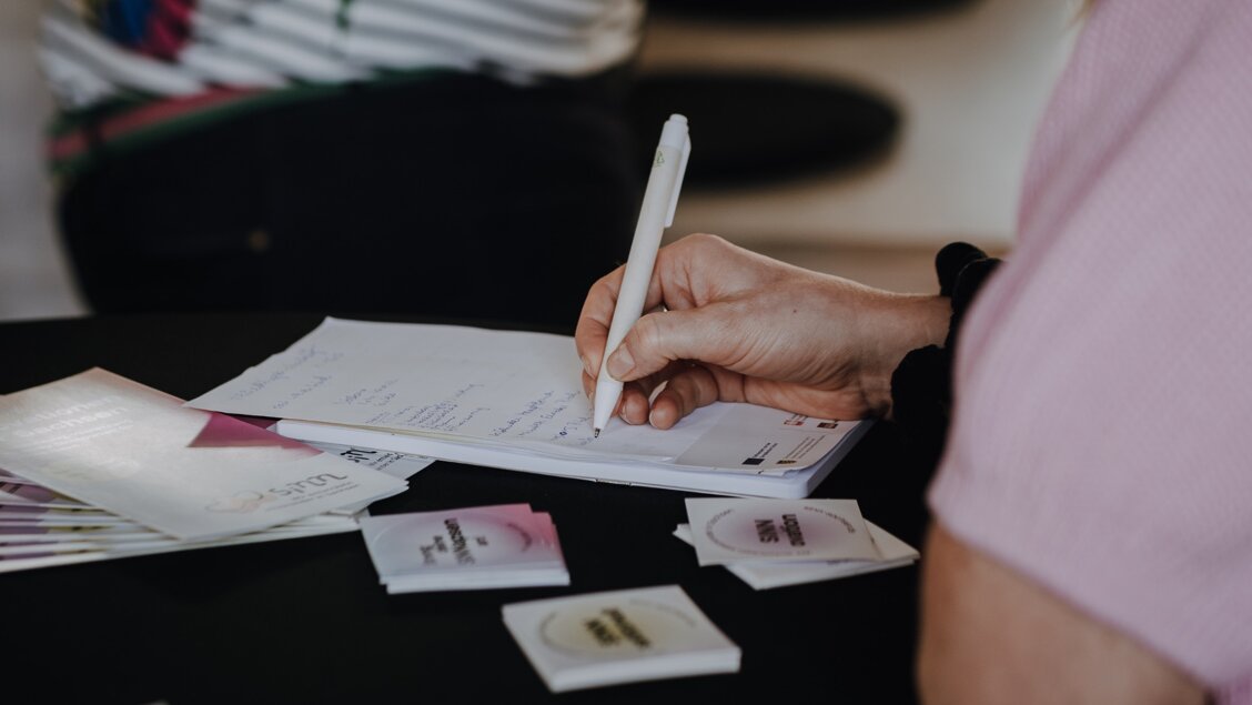 Das Bild ist ein Ausschnitt und zeit, wie jemand etwas auf einen Block schreibt. Vom Menschen sieht man nur Hand und Arm. - 4. Förderrunde für Modellvorhaben - Schwerpunkt KI Reicht eure Anträge bis zum 07.05. ein
