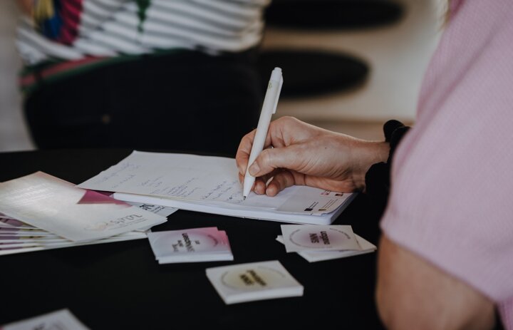 Das Bild ist ein Ausschnitt und zeit, wie jemand etwas auf einen Block schreibt. Vom Menschen sieht man nur Hand und Arm. - Link: 4. Förderrunde für Modellvorhaben - Schwerpunkt KI Reicht eure Anträge bis zum 07.05. ein