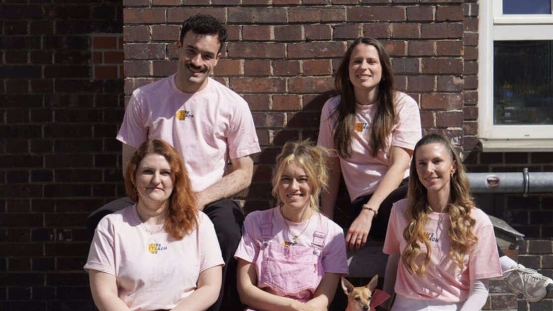 Fünf menschen in Rosa Shirts sitzen vor eine Wand. Sie lächeln in die Kamera. - Das Innovations-Sofa. Diesmal mit LifeTeachUs